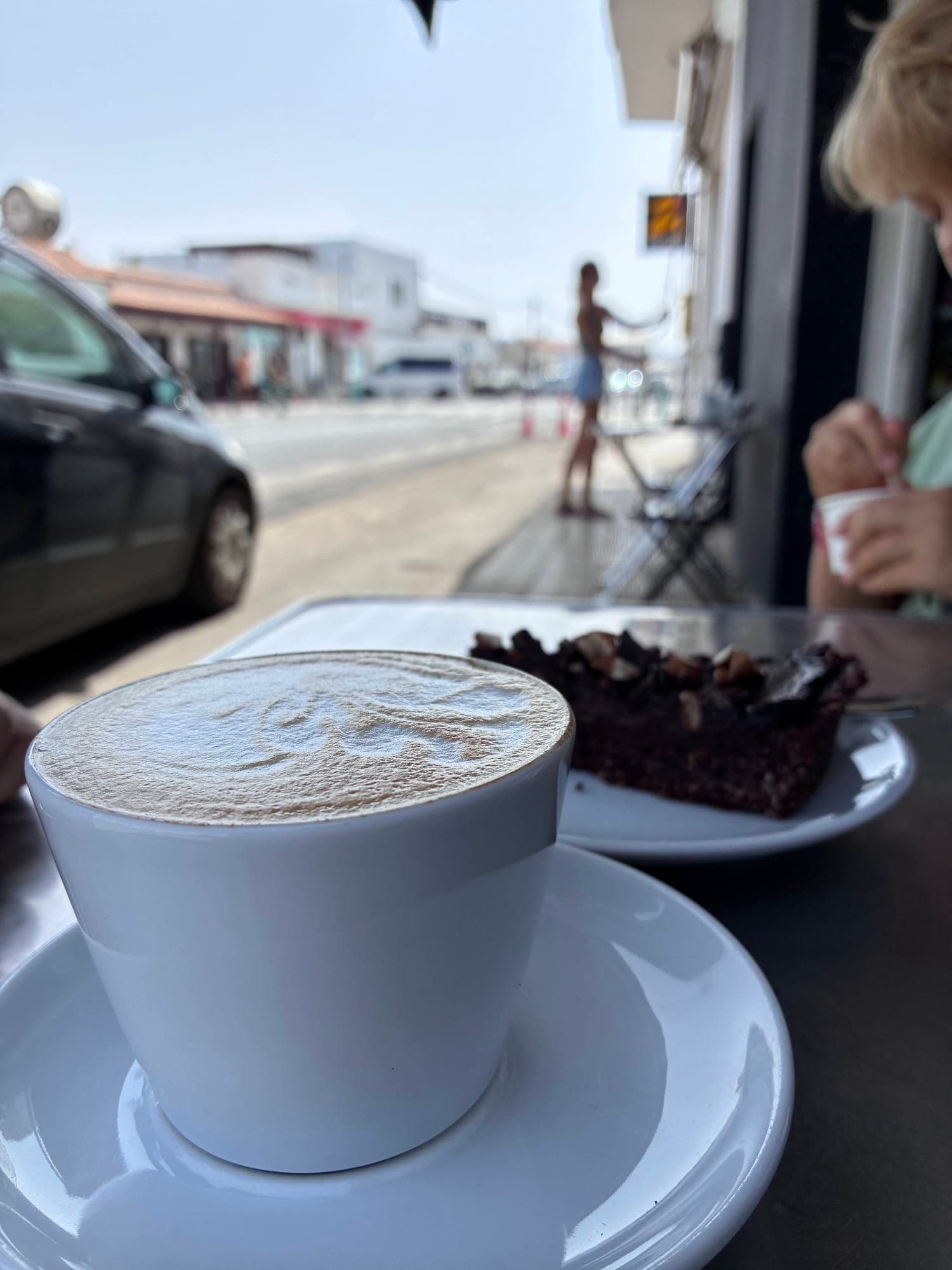 Cappuccino and chocolate cake at a street cafe