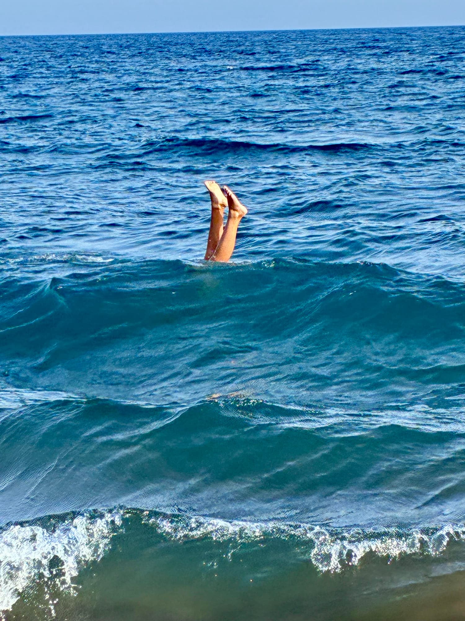Handstand in the turquoise ocean waves